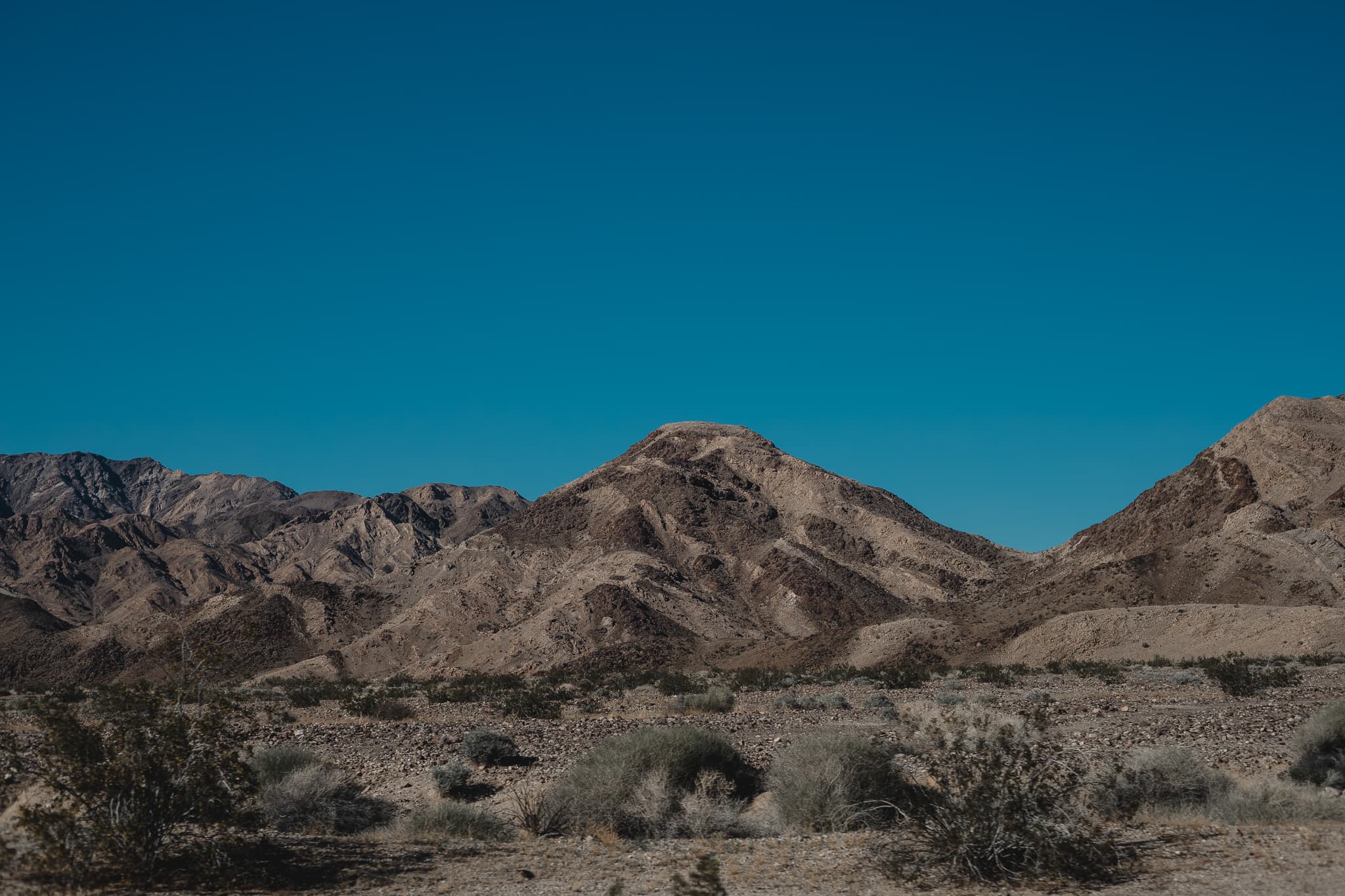 Desert mountain range under deep blue sky