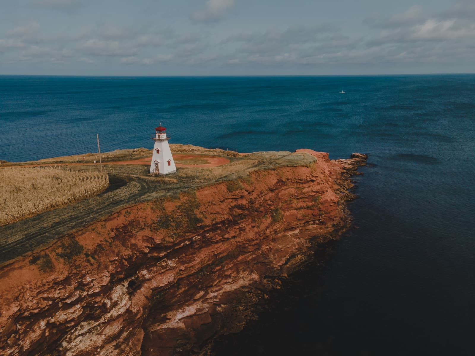Lighthouse on red cliff above the ocean